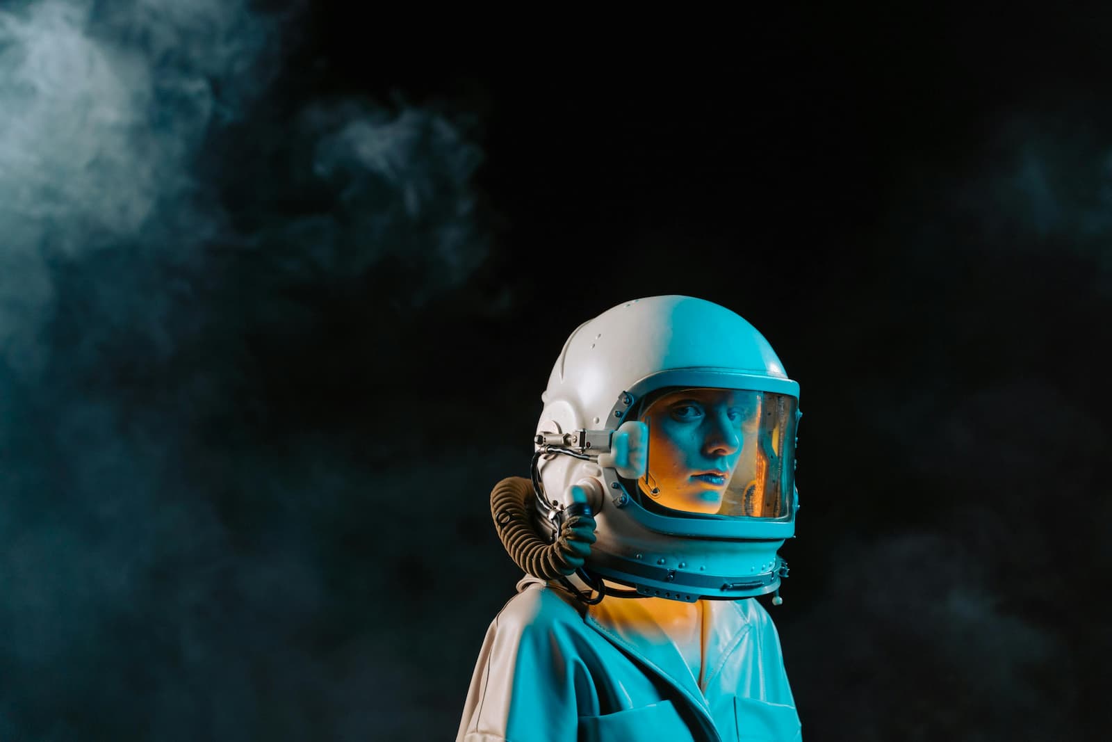 A man in a white leather coat, wearing an astronaut like helmet.