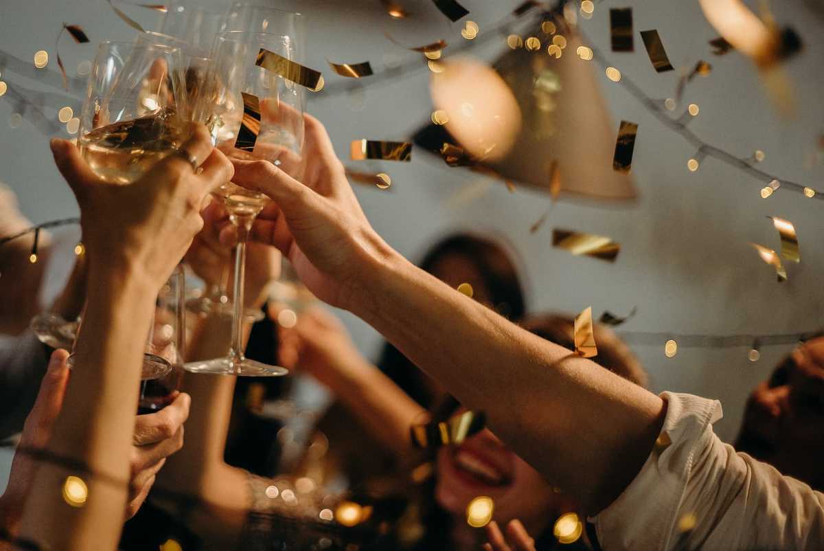 People celebrate and raise glasses of wine for a toast.